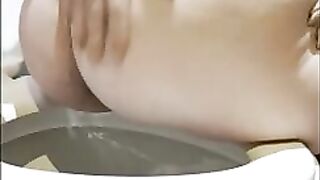 Chubby gal shits into her hand over the toilet